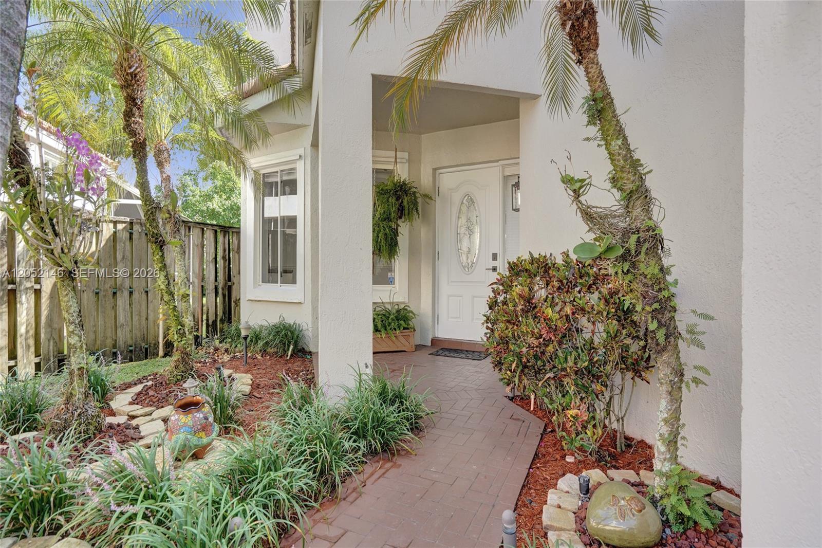 A brick walkway leads to a white front door under a covered entryway — 10073 NW 5th St, Plantation FL 33324, PLANTATION, FL