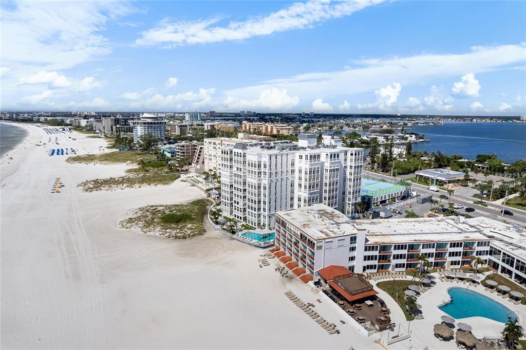 An aerial view of a beachfront resort complex with multiple buildings and swimming pools — 4950 GULF BOULEVARD UNIT 807, ST PETE BEACH, FL