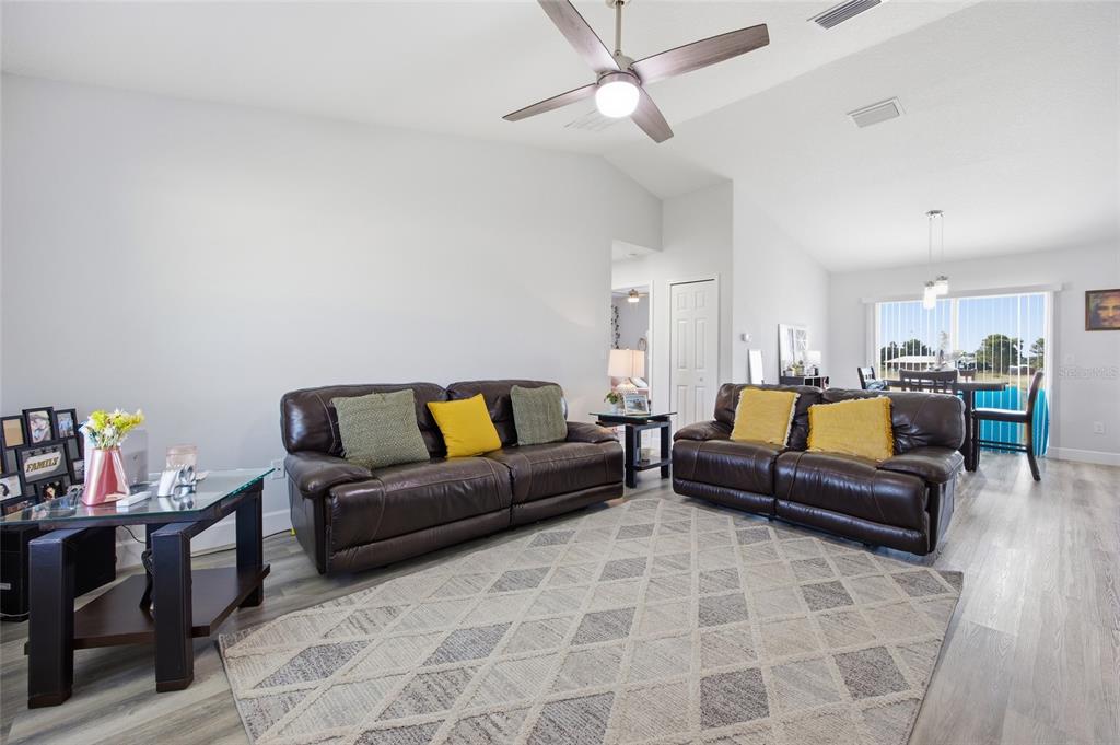 A living room features two brown leather sofas, a patterned area rug, and a ceiling fan — 14960 SW 33RD LANE, OCALA, FL