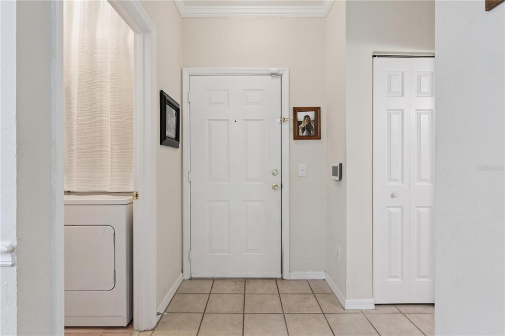 A tiled entryway features a white front door, a laundry closet, and a storage closet — 3751 CONROY ROAD UNIT 2325, ORLANDO, FL