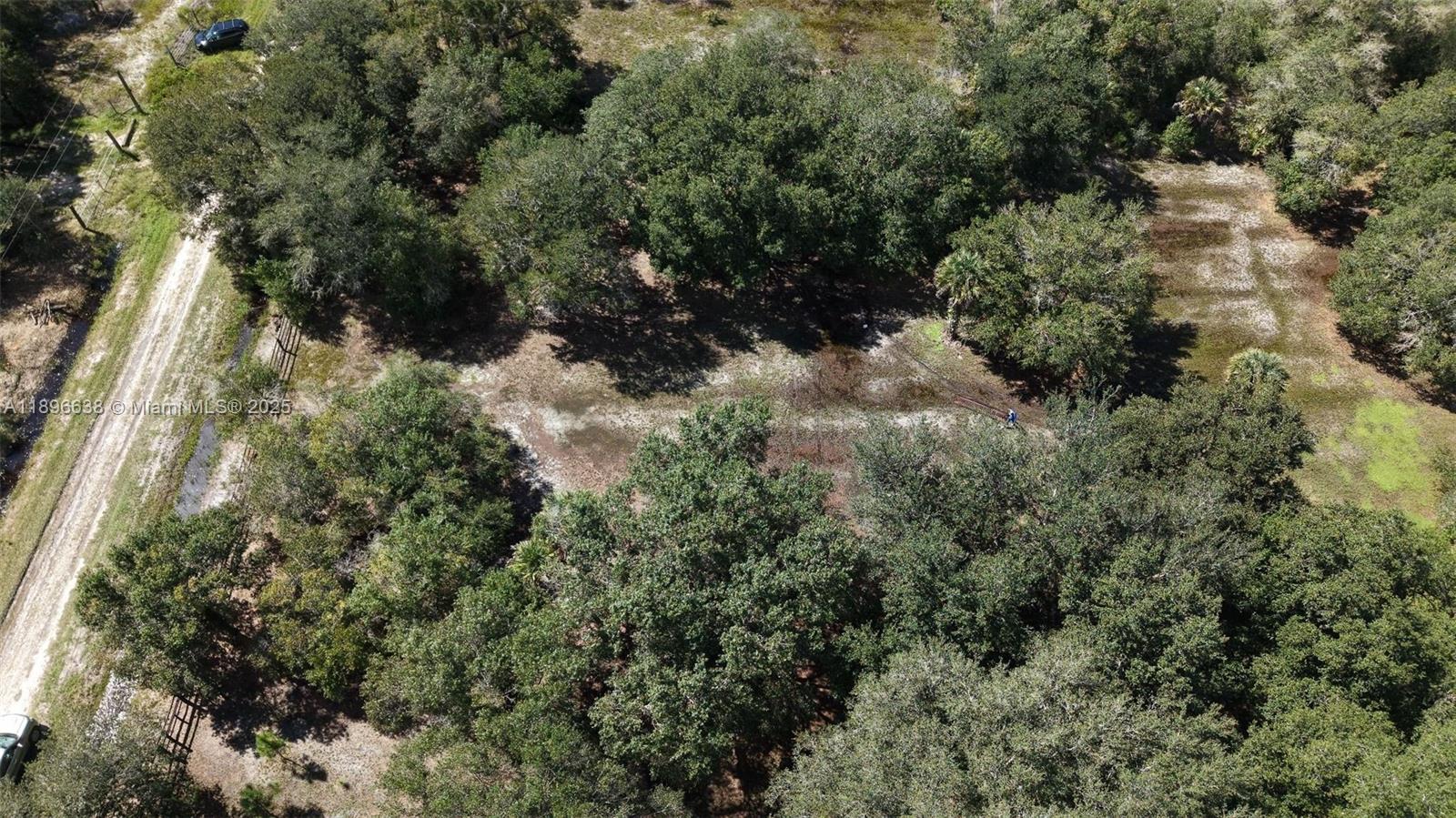 An aerial view shows a wooded lot with a dirt path and scattered trees — 20125 NW 300TH ST, Okeechobee FL 34972, OKEECHOBEE, FL