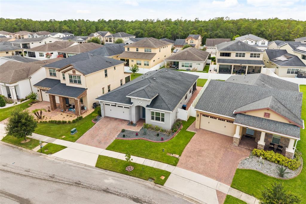 An aerial view shows three suburban houses with paved driveways and manicured lawns — 3118 RESIDENCE EAST WAY, ORLANDO, FL
