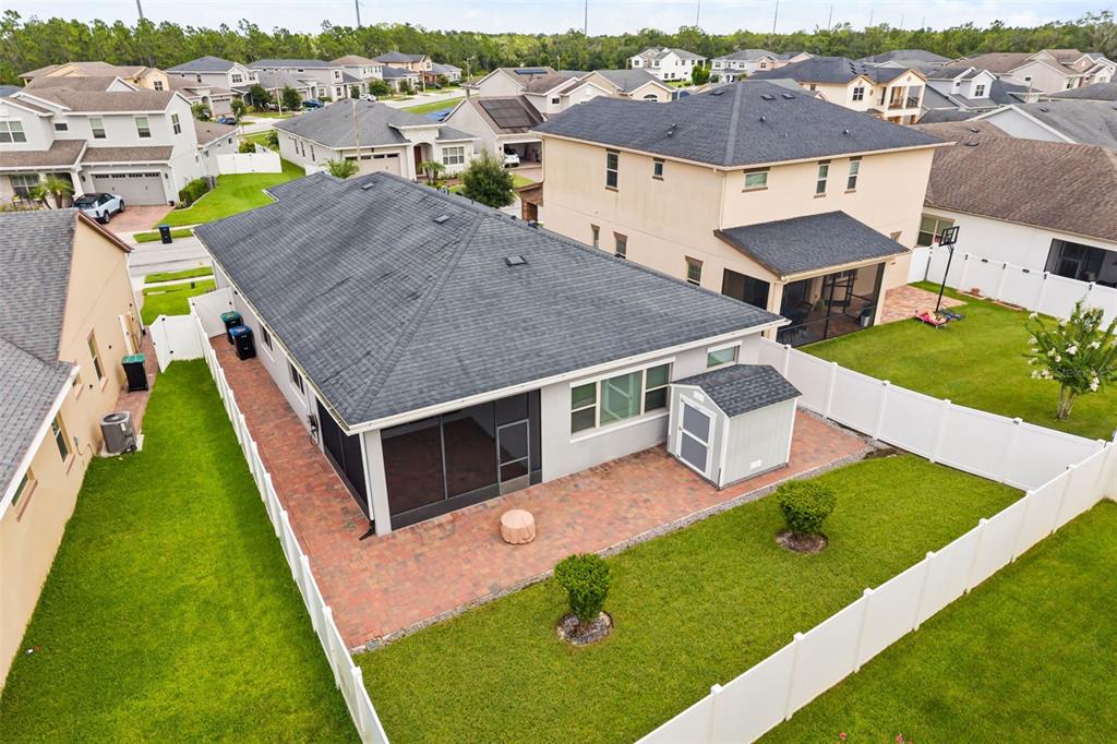 An aerial view shows a house with a paved patio, screened porch, and backyard shed — 3118 RESIDENCE EAST WAY, ORLANDO, FL