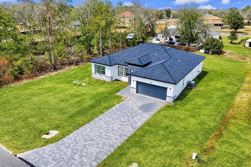 An aerial view shows a modern single-story house with a dark roof and paved driveway — 11591 SW 59TH TERRACE, OCALA, FL