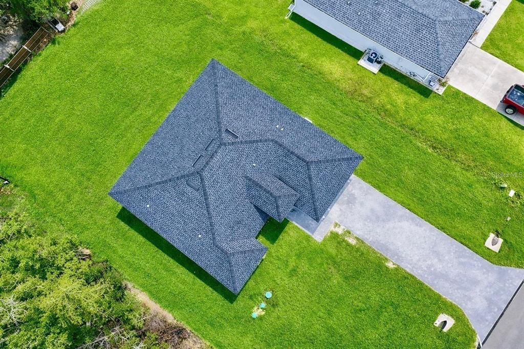 An aerial view shows a single-story house with a dark shingled roof and concrete driveway — 11591 SW 59TH TERRACE, OCALA, FL