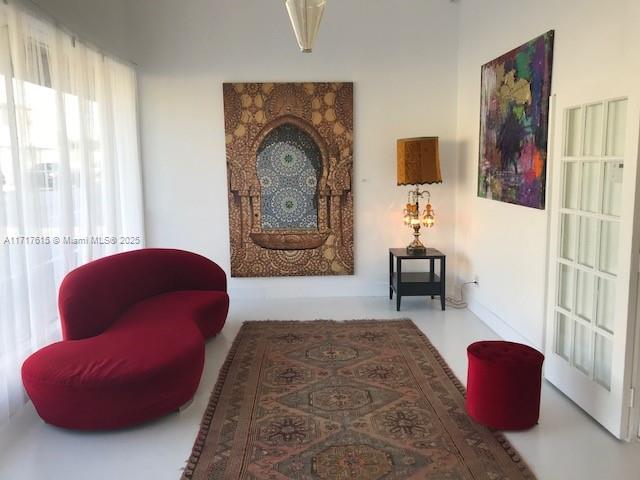 A living room features a red curved sofa, a patterned rug, and a wall tapestry — 5600 NW 7th Ave, Miami FL 33127, MIAMI, FL
