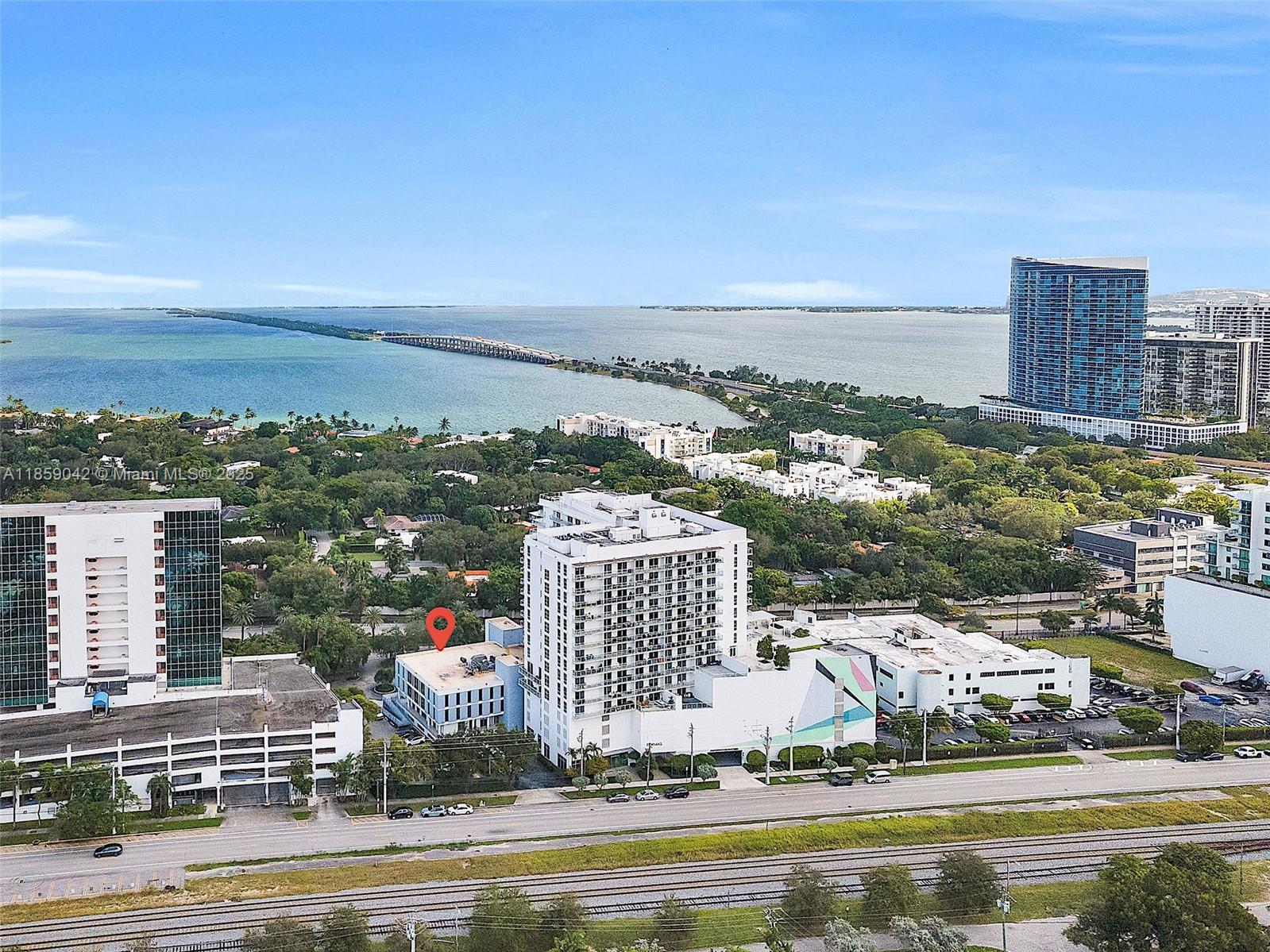 An aerial view shows a multi-story building with a red location pin near a bay — 4300 Biscayne Blvd # G05, Miami FL 33137, MIAMI, FL