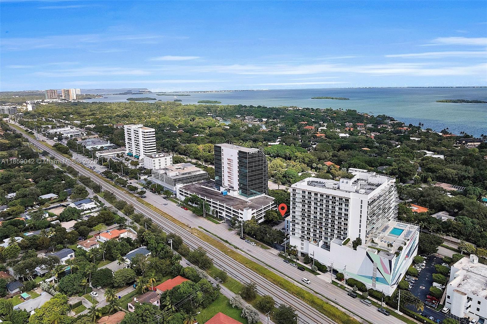 An aerial view shows a multi-story building with a pool, adjacent to train tracks — 4300 Biscayne Blvd # G05, Miami FL 33137, MIAMI, FL