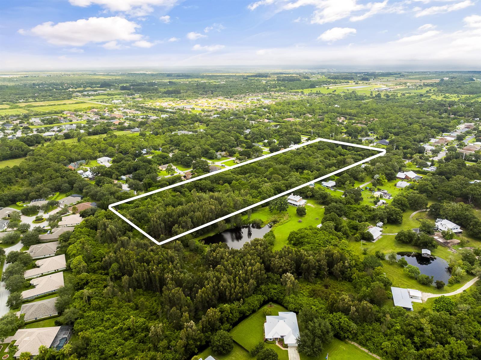 An aerial view shows a rectangular plot of land outlined in white amidst a wooded area — 6145 45th Street, Vero Beach FL 32967, VERO BEACH, FL