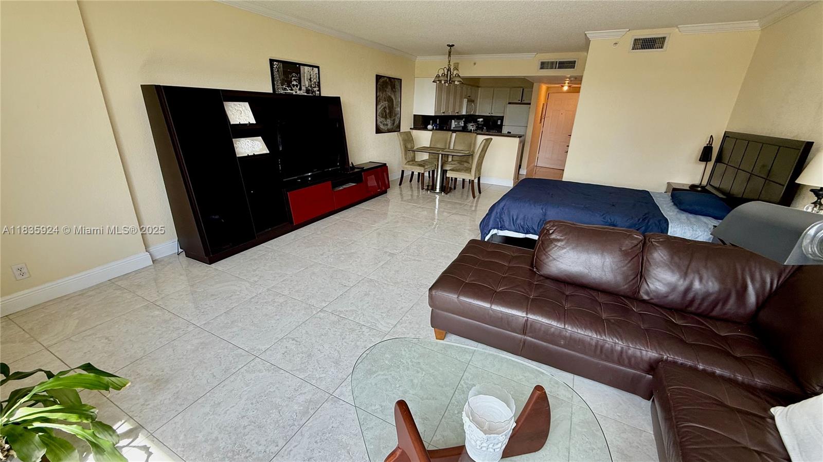 An open-concept studio apartment features a living area, dining set, and bed on tiled floors — 2501 S Ocean Dr # 427, Hollywood FL 33019, HOLLYWOOD, FL