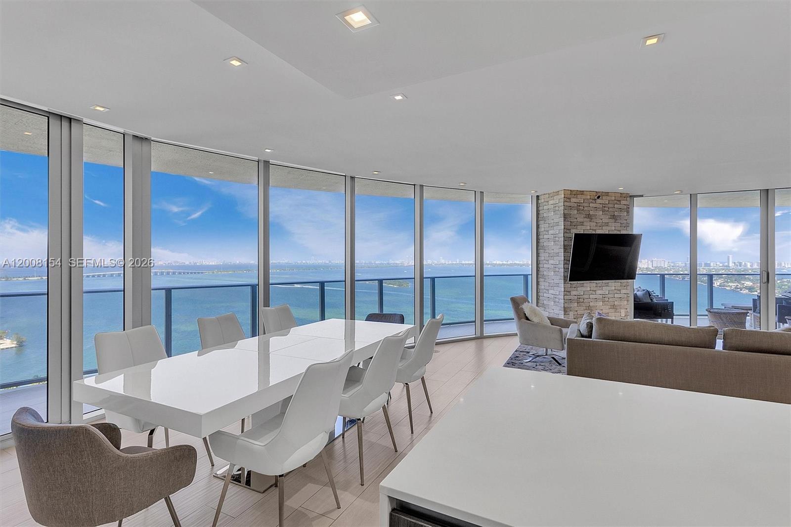 A modern dining and living area features floor-to-ceiling windows with expansive ocean views — 488 NE 18th St # 2315, Miami FL 33132, MIAMI, FL