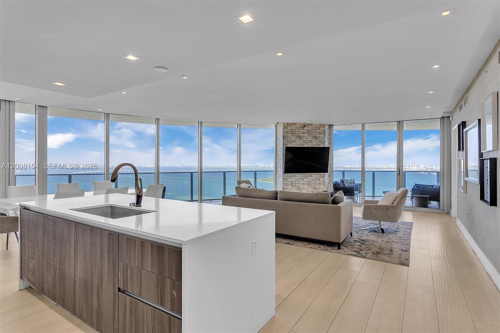 A modern open-concept kitchen and living area features floor-to-ceiling windows with panoramic ocean views — 488 NE 18th St # 2315, Miami FL 33132, MIAMI, FL