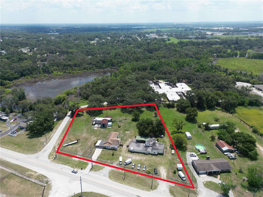 An aerial view shows a large, irregularly shaped property containing multiple buildings and a pool — 13330 FORT KING ROAD, DADE CITY, FL