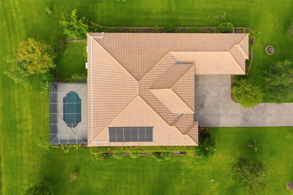 An aerial view shows a house with a tiled roof, a pool enclosure, and solar panels — 8420 WEBBER ROAD, SARASOTA, FL