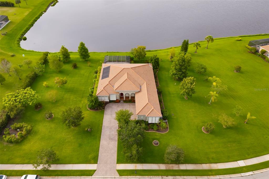 An aerial view shows a single-story house with a tile roof situated on a large lot — 8420 WEBBER ROAD, SARASOTA, FL