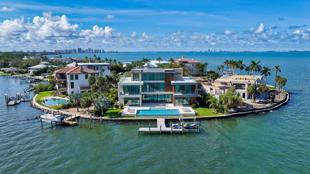 An aerial view of a modern waterfront mansion with a pool and private boat dock — 305 S SHORE DRIVE S, SARASOTA, FL