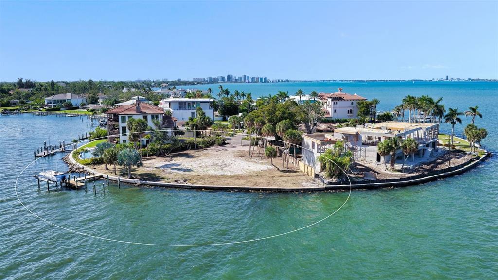 An aerial view shows a waterfront lot with a boat dock and two houses — 305 S SHORE DRIVE S, SARASOTA, FL