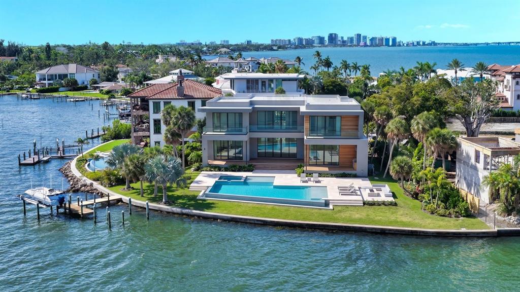 An aerial view of a modern waterfront home with a swimming pool and private dock — 305 S SHORE DRIVE S, SARASOTA, FL