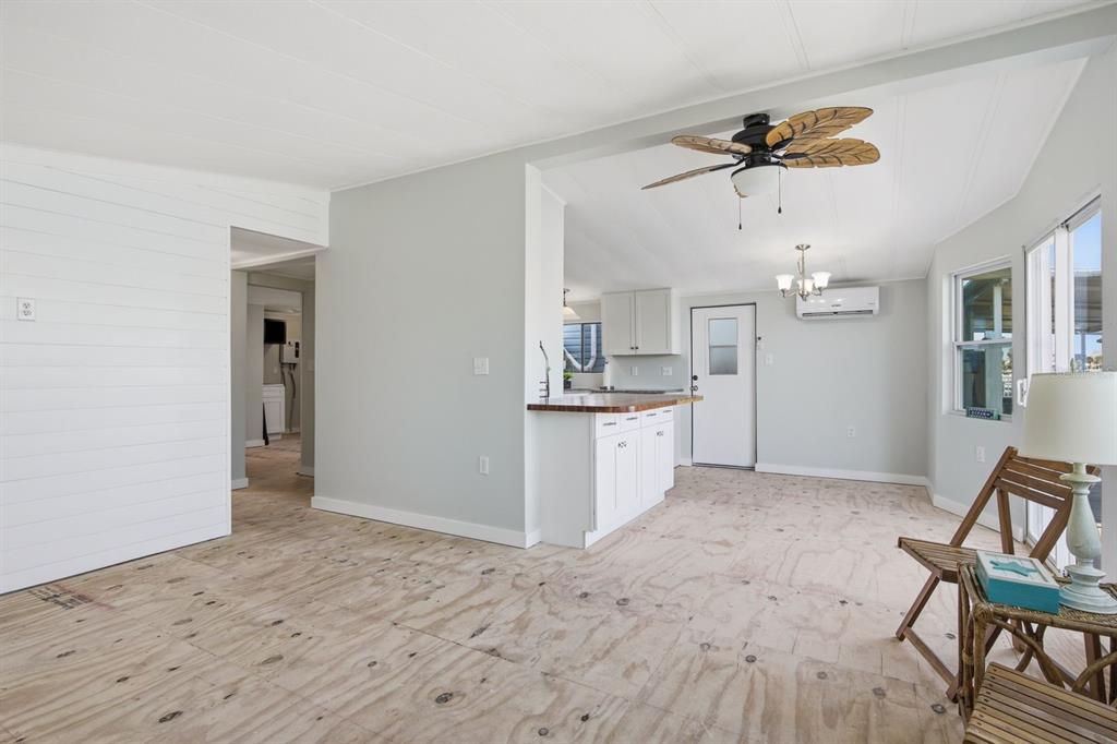 An interior view showing a kitchen with a breakfast bar and unfinished plywood flooring — 15010 113TH AVENUE UNIT 12, LARGO, FL