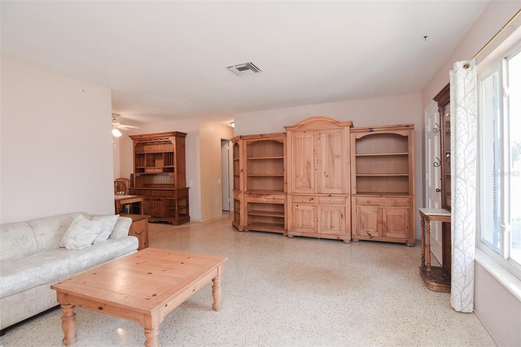 A living room with light-colored walls, terrazzo floors, wooden furniture, and a large window — 11319 70TH TERRACE, SEMINOLE, FL