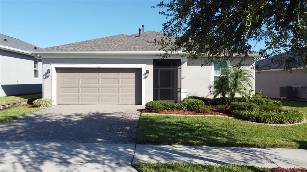 A single-story house with a two-car garage, a screened entryway, and a paved driveway — 537 NARROW VIEW LANE, GROVELAND, FL
