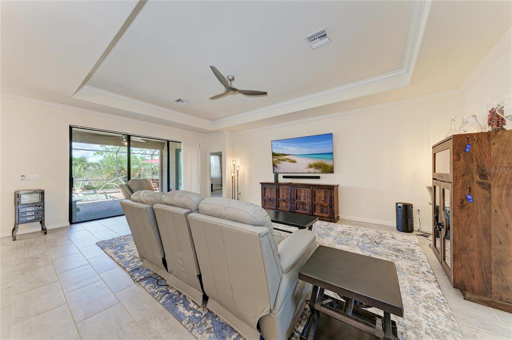 A living room features light tile floors, a tray ceiling, and a sliding glass door — 20706 BENISSIMO DRIVE, VENICE, FL