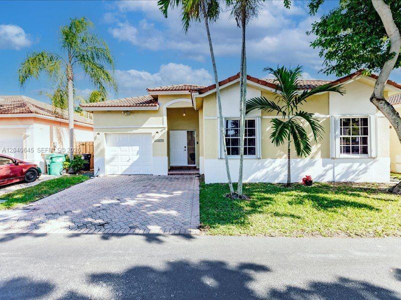A single-story house with a paved driveway, palm trees, and a white garage door — 21475 SW 90th Pl, Cutler Bay FL 33189, CUTLER BAY, FL