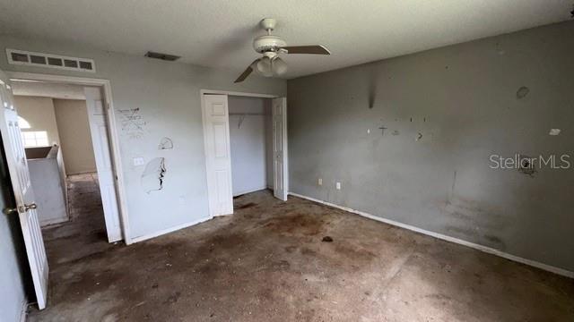 An empty bedroom features gray walls, a ceiling fan, and a stained concrete floor — 464 MARTIGUES DRIVE, KISSIMMEE, FL