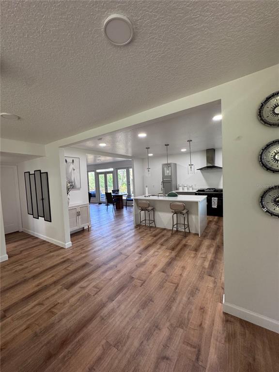 An open-concept kitchen features a white island, pendant lighting, and wood-look flooring — 10731 LIBBY NUMBER 3 ROAD, CLERMONT, FL