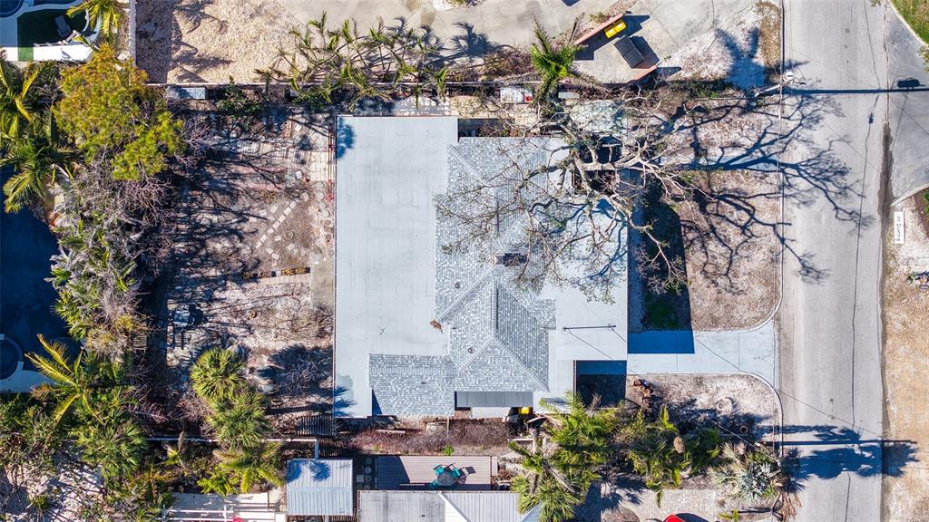 An aerial view shows a house with a shingled roof surrounded by trees and landscaping — 132 HARRISON DRIVE, SARASOTA, FL