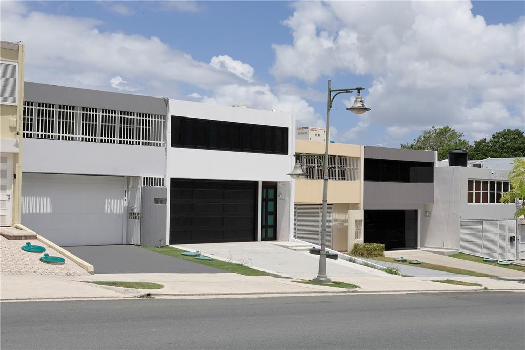 A street-level view of several modern, multi-story townhouses with garages and white or grey facades — 632-5 AVE. SAN PATRICIO, GUAYNABO, PR
