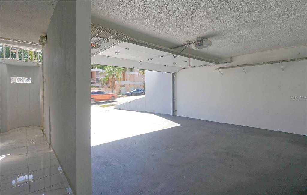 An open garage with a concrete floor, white walls, and a raised sectional door — 632-5 AVE. SAN PATRICIO, GUAYNABO, PR