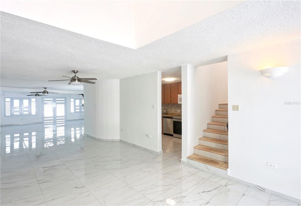 A living room with white marble floors, a vaulted ceiling, and stairs leading to another level — 632-5 AVE. SAN PATRICIO, GUAYNABO, PR