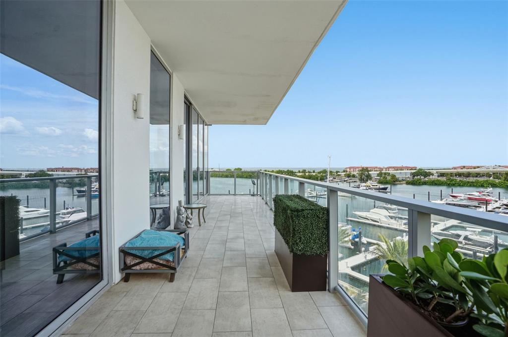 A balcony with tile flooring overlooks a marina filled with boats under a clear sky — 5120 MARINA WAY UNIT 4408, TAMPA, FL