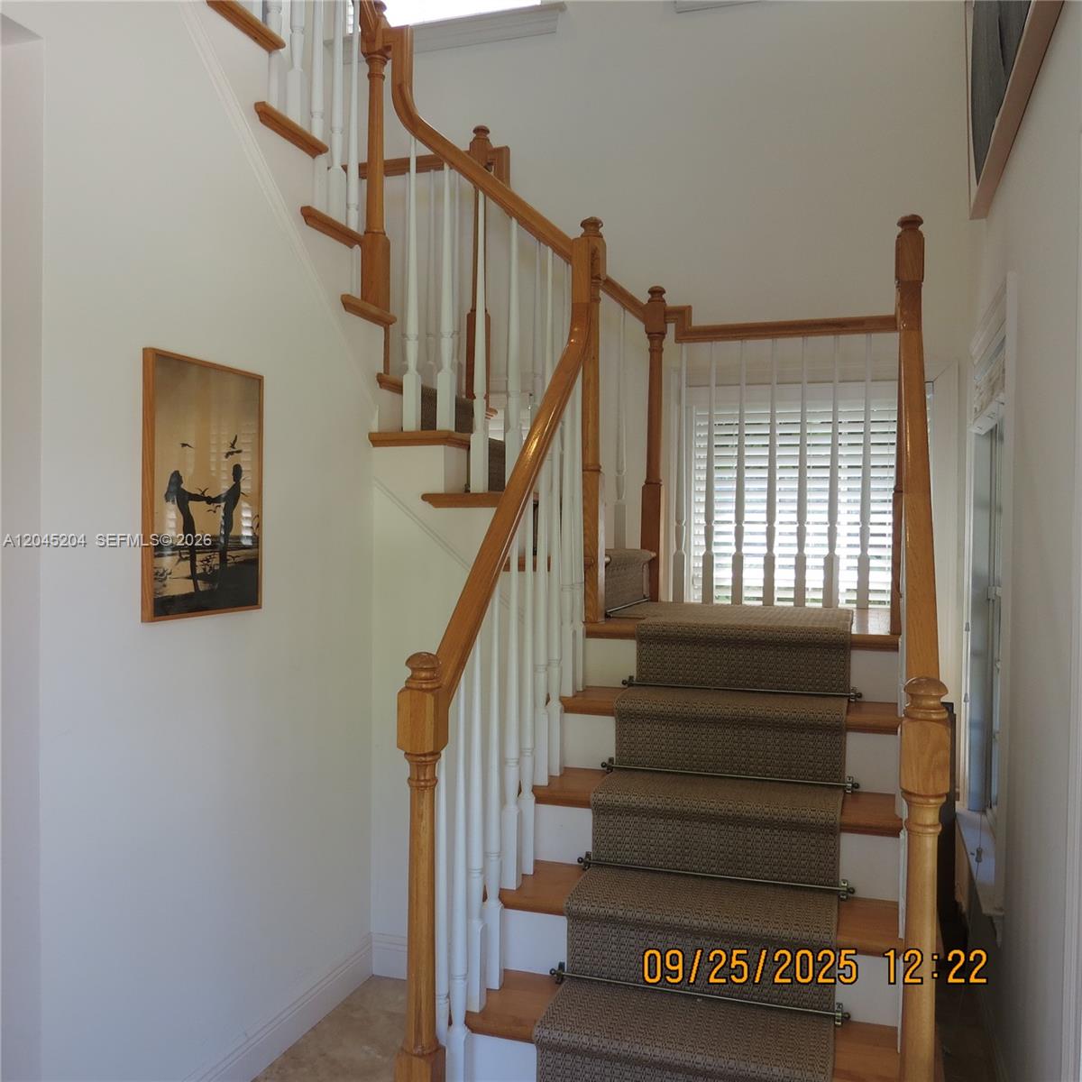 A staircase with wooden handrails, white balusters, and a carpet runner leads to a landing — 404 S Beach Rd # 404, Jupiter Island FL 33455, JUPITER ISLAND, FL