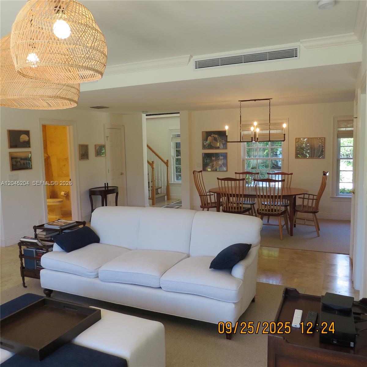 A white sofa sits in a living room adjacent to a dining area with wooden chairs — 404 S Beach Rd # 404, Jupiter Island FL 33455, JUPITER ISLAND, FL