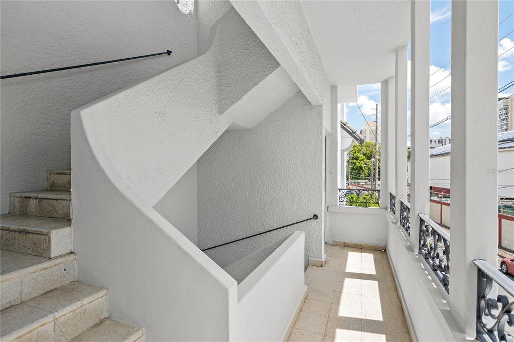 An outdoor staircase with white stucco walls and metal railings leads to a tiled balcony — 107 TAFT UNIT 5, SAN JUAN, PR