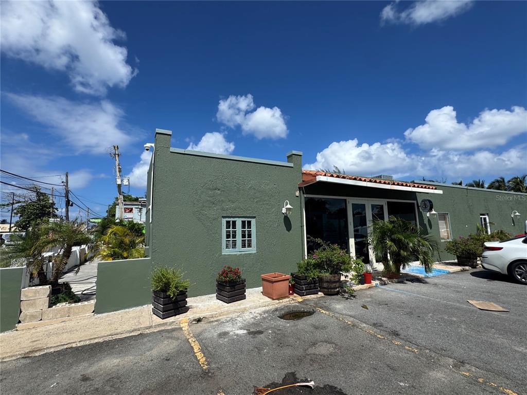 A green, single-story commercial building with a parking lot and blue sky above — 2475 LOÍZA STREET, SAN JUAN, PR