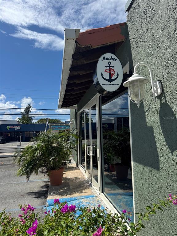 The exterior of a seafood market features a hanging sign, a light fixture, and potted plants — 2475 LOÍZA STREET, SAN JUAN, PR