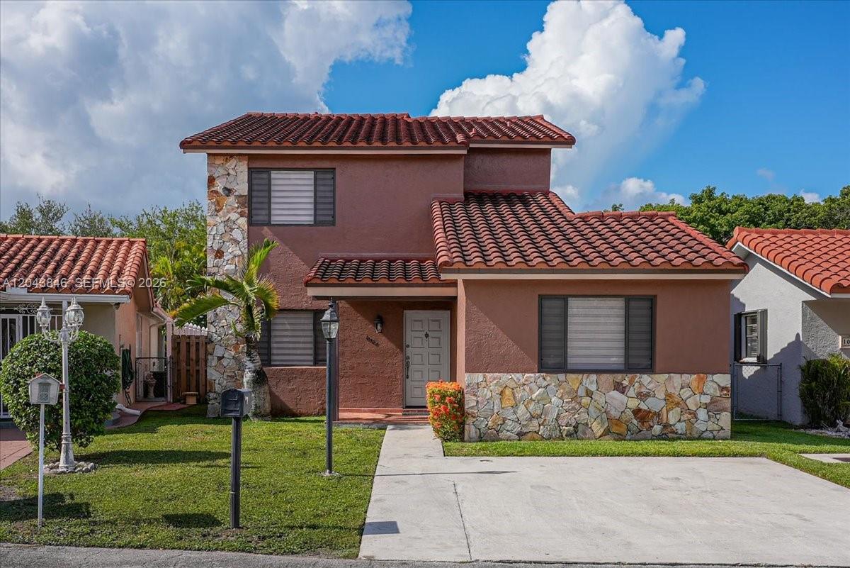 A two-story house with a brown stucco exterior, stone accents, and a red tile roof — 10528 SW 69th Ter, Miami FL 33173, MIAMI, FL