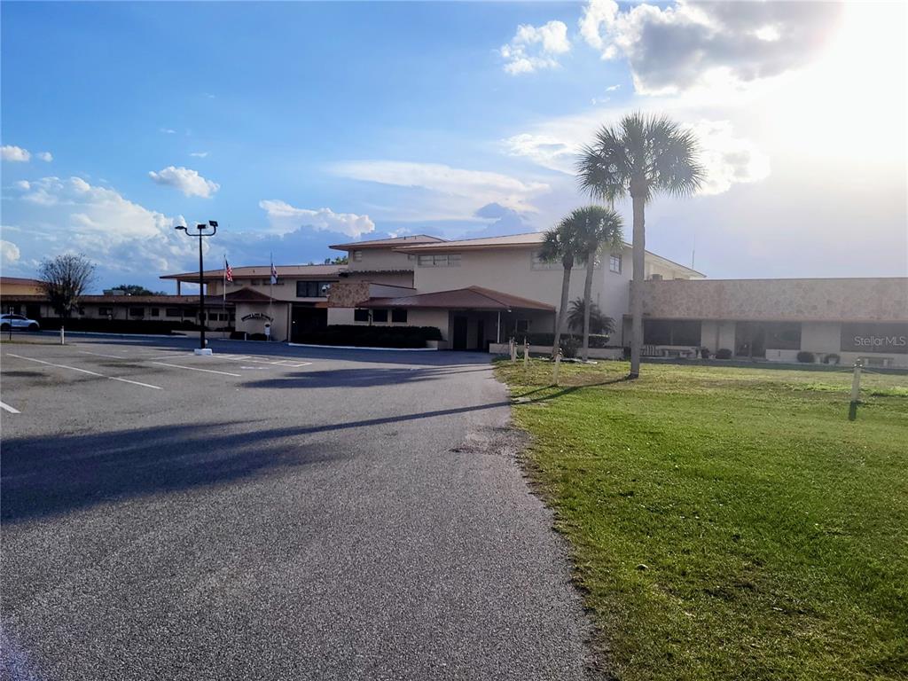 A low-rise commercial building with a parking lot and palm trees under a sunny sky — 0 SW ORLANDO DRIVE UNIT 10, INDIAN LAKE ESTATES, FL