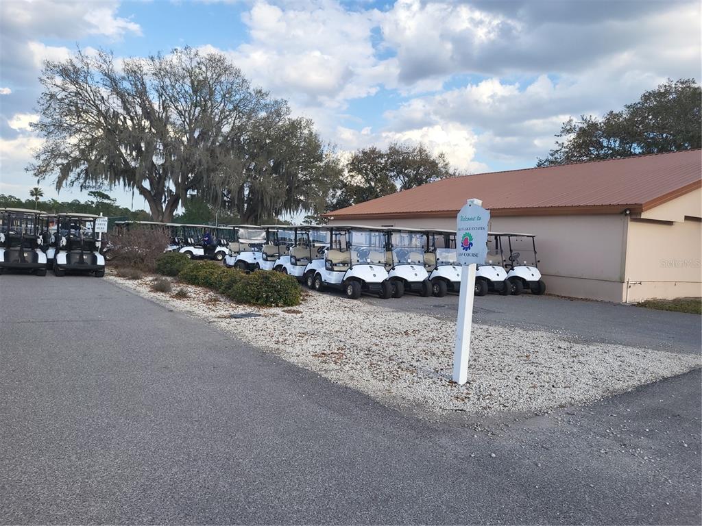 A row of white golf carts is parked next to a building with a brown roof — 0 SW ORLANDO DRIVE UNIT 10, INDIAN LAKE ESTATES, FL