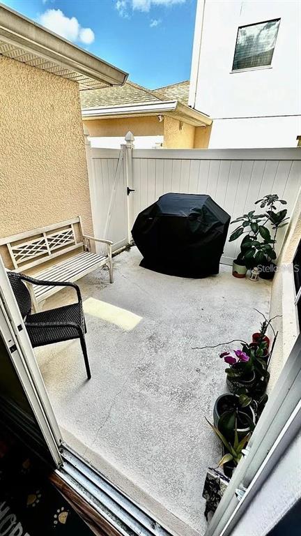 A small concrete patio features a covered grill, a bench, and several potted plants — 12621 TANJA KING BOULEVARD, ORLANDO, FL