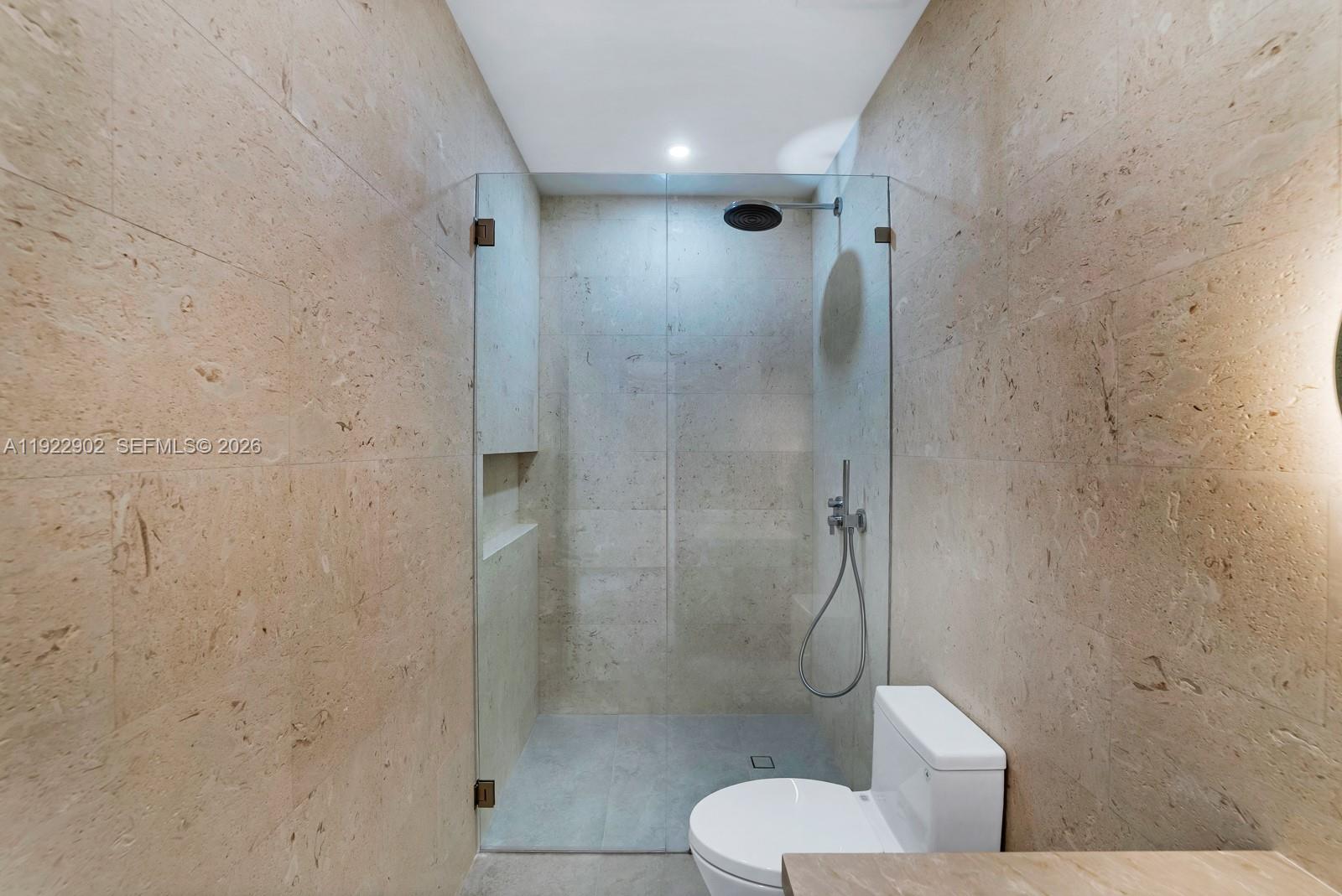 A bathroom features a glass-enclosed walk-in shower with light-colored stone tile walls — 2610 SW 17th St, Miami FL 33145, MIAMI, FL