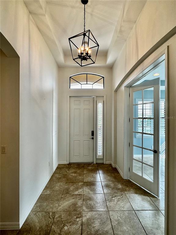 A tiled entryway features a geometric pendant light, a white front door, and French doors — 1321 CIELO COURT, NOKOMIS, FL