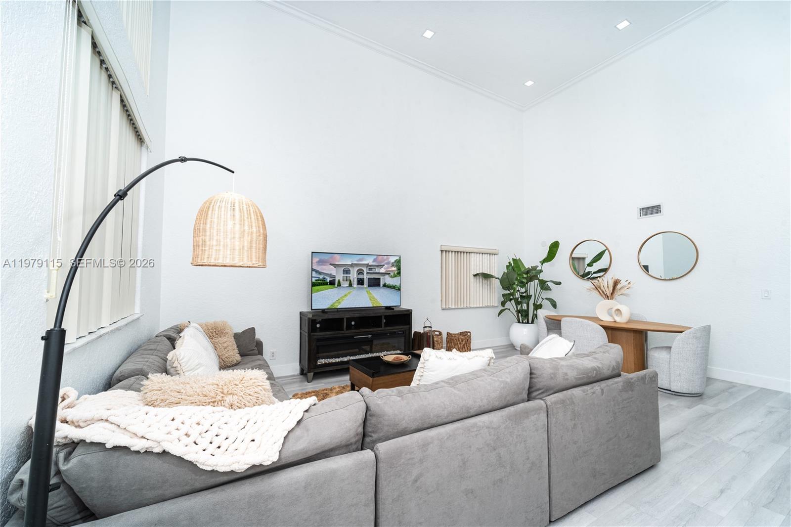A living room features a large grey sectional sofa, a television, and high ceilings — 14172 NW 87th Ct, Miami Lakes FL 33018, MIAMI LAKES, FL