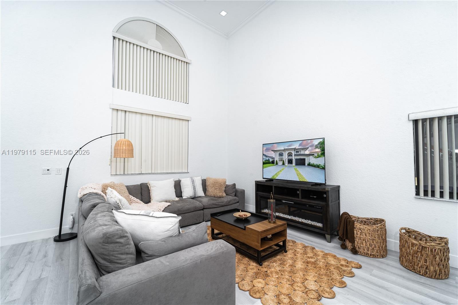 A living room features high ceilings, a grey sectional sofa, and a television console — 14172 NW 87th Ct, Miami Lakes FL 33018, MIAMI LAKES, FL