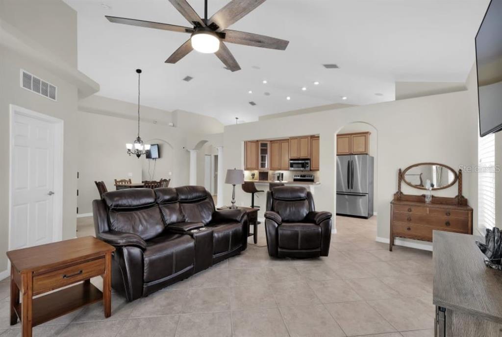 A living room with tile floors, leather furniture, and an open kitchen in the background — 90 W WATERSIDE PARKWAY, PALM COAST, FL