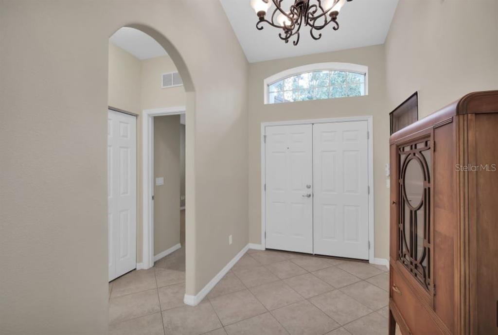 A tiled entryway features a high ceiling, a chandelier, and double front doors — 90 W WATERSIDE PARKWAY, PALM COAST, FL