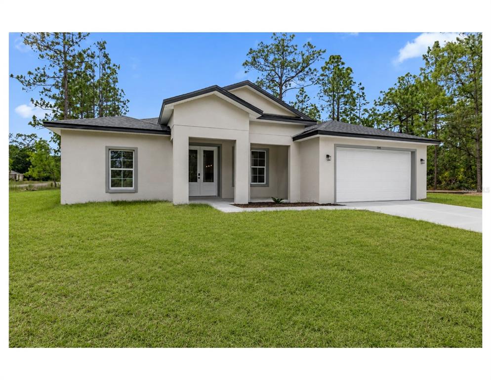 A single-story house with a white stucco exterior, a two-car garage, and a front porch — 7295 N GLENRIDGE CIRCLE, CITRUS SPRINGS, FL